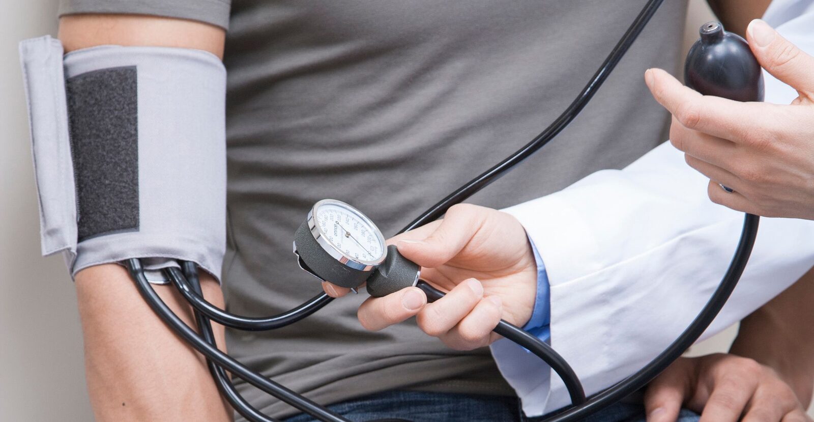 A clinician checking a patient's blood pressure during an office visit